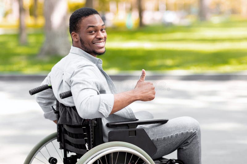 Happy Disabled Black Man in Wheelchair Spending Time at City Park in Autumn, Showing Thumb Up Gesture and Smiling Stock Photo - Image of handicap, recovery: 356214140